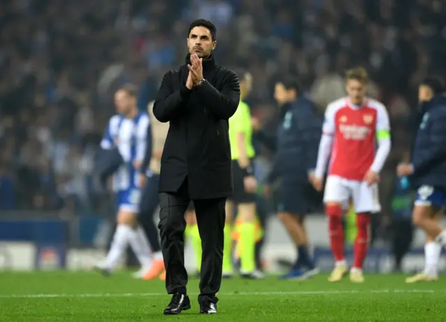 Arteta applauds the away fans from the pitch with a glum expression.