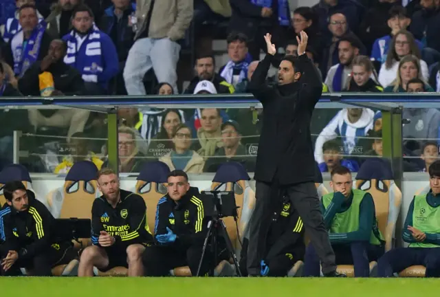 Arteta applauds his team from in front of his dugout.