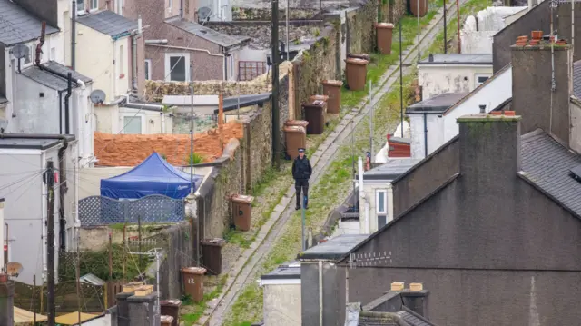 Police officer stands in an alley