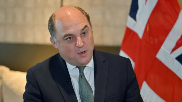 Ben Wallace speaks during an interview next to a Union Jack flag