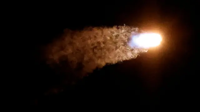 The shuttle is seen shooting off into the dark sky