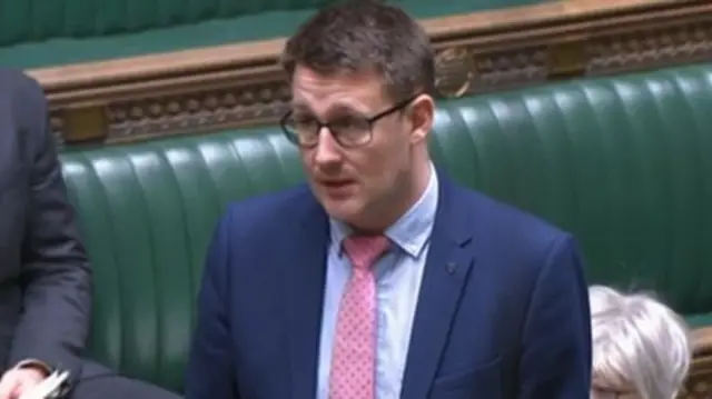 David Linden, wearing a blue suit and pink tie, speaks in the Commons