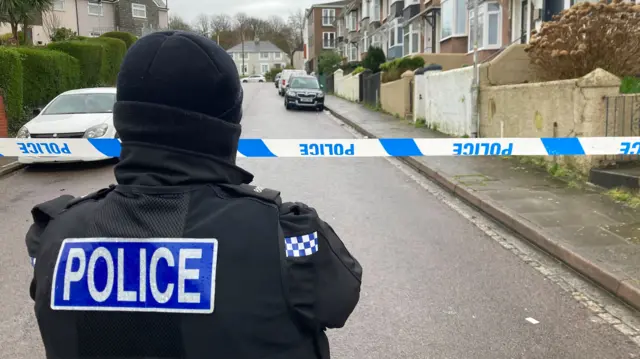 Back of police officer facing cordoned off area