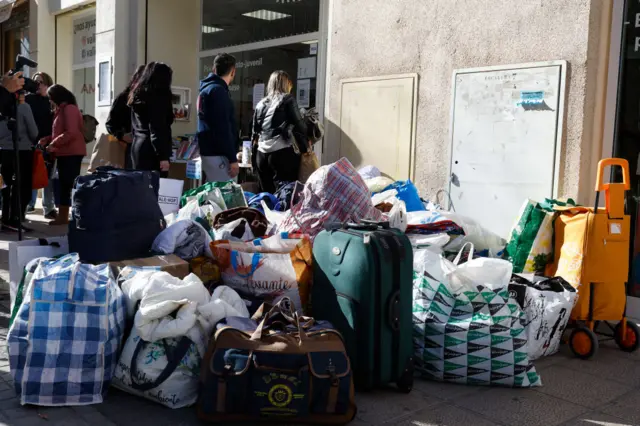 Bags of donations begin to pile up as local residents contribute clothes to help residents of the fire-struck buildings