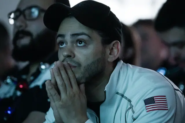 Mario Romero watching a screen, resting his hands on his chin