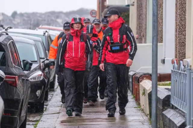 Members of Dartmoor Rescue Group by the police cordon after a suspected Second World War explosive device was discovered in a garden on St Michael Avenue in Plymouth. Picture date: Thursday February 22, 2024