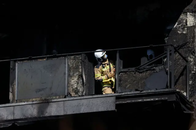 A firefighter inspects the aftermath of a huge fire that yesterday raged through a multistorey residential block killing at least four people, in Valencia on February 23, 2024