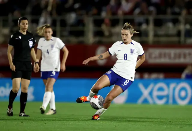 Clinton dribbles the ball in midfield.