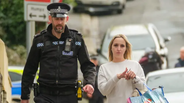 A police officer speaks to a member of the public after homes were evacuated when a suspected Second World War explosive device was discovered in a garden on St Michael Avenue in Plymouth. Picture date: Thursday February 22, 2024