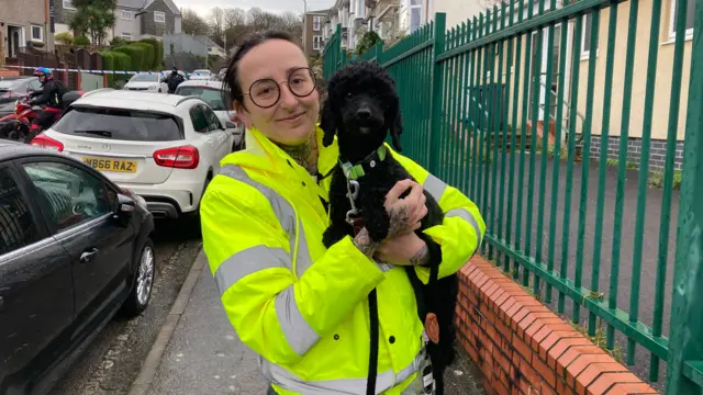 Photo of local resident being evacuated with dog