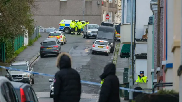 Members of HM Coastguard Search and Rescue gather after homes were evacuated