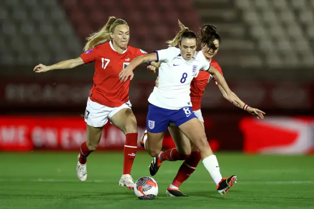 Clinton tries to dribble away from two Austria midfielders.