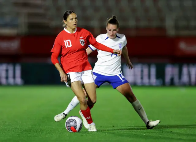 Feiersinger dribbles in midfield with Toone in pursuit.