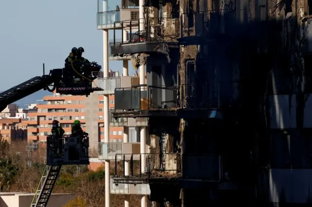 Firefighters work at the scene of a fire in an apartment building in Valencia, Spain, February 23, 2024.