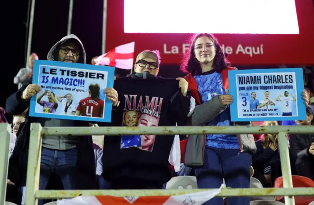 England fans hold up signs in support of the England players.