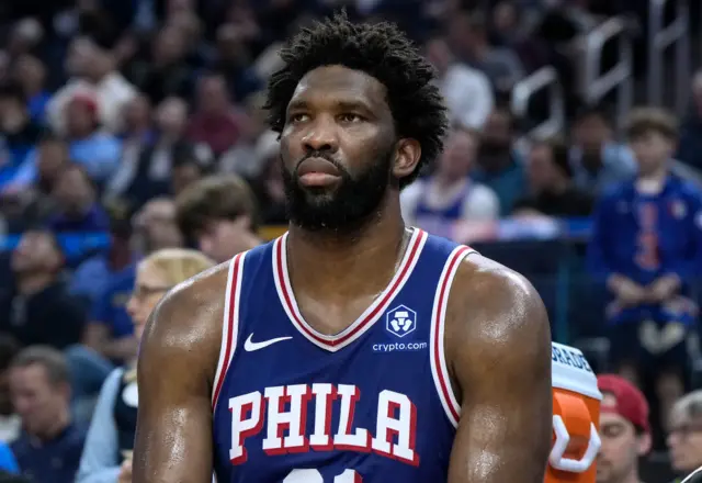 Joel Embiid sitting on the bench during a Philadelphia 76ers game.