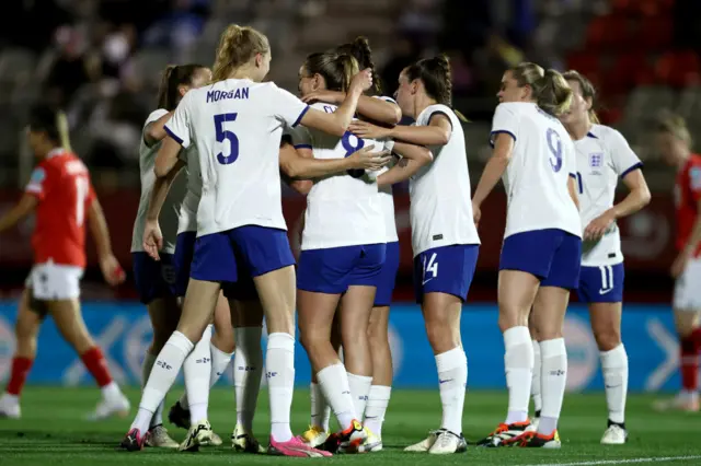 England players flock Grace Clinton after her debut goal.