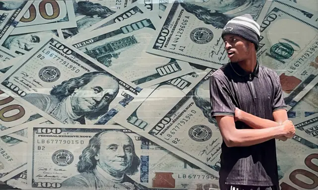 A man waits outside a currency exchange bureau in Nairobi, Kenya