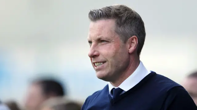 Neil Harris smiling on the touchline