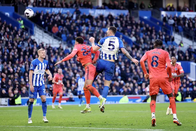 Lewis Dunk of Brighton & Hove Albion wins a header against Ben Godfrey o