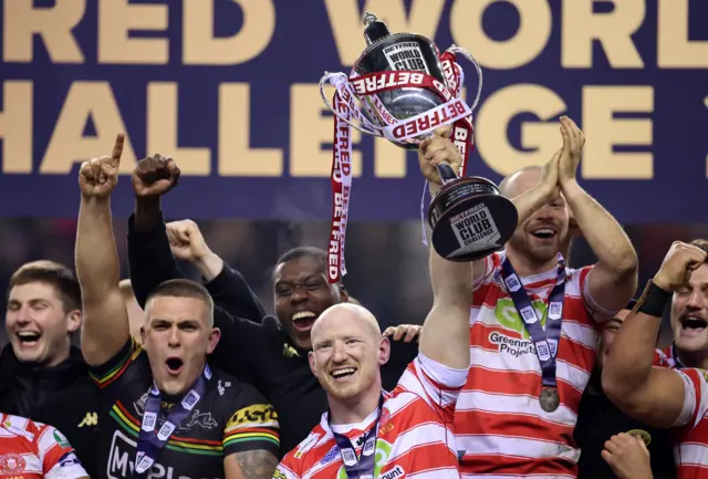 Wigan captain Liam Farrell lifts the World Club Challenge trophy