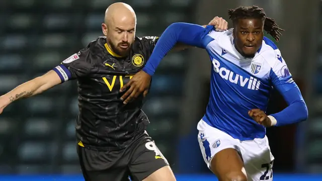 Gillingham and Stockport players challenge for the ball