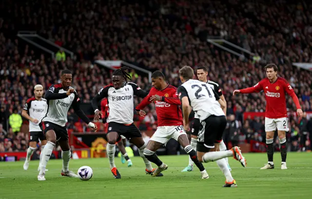 Calvin Bassey of Fulham challenges Marcus Rashford