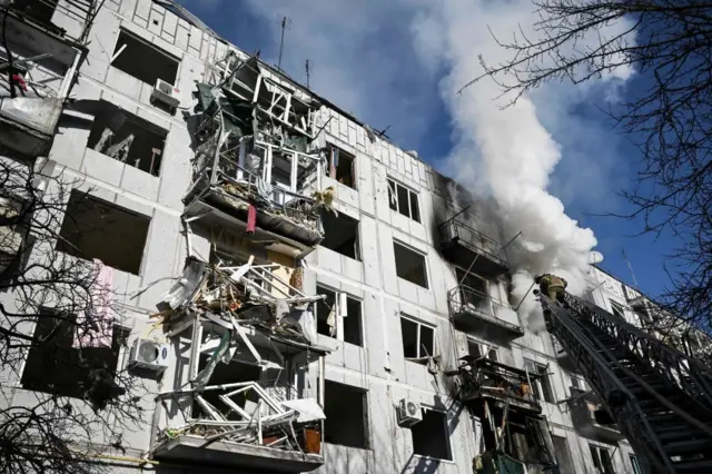 Smoke billows over a damaged building after bombings on the eastern Ukraine town of Chuguiv on 24 February 2022, as Russian armed forces tried to invade Ukraine from several directions.