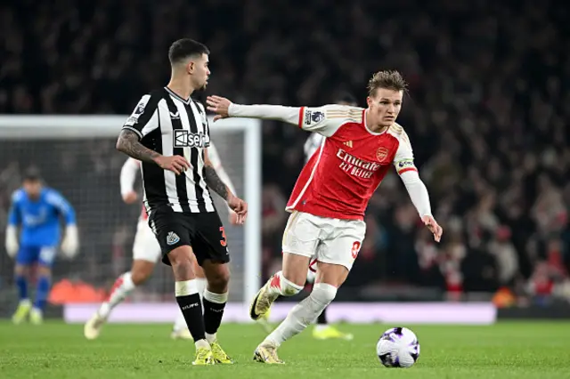 Martin Odegaard of Arsenal runs with the ball whilst under pressure from Bruno Guimaraes