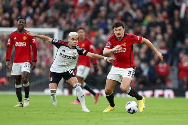 Harry Maguire of Manchester United runs with the ball whilst under pressure from Andreas Pereira