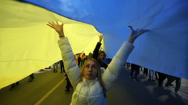 People carry a huge Ukrainian flag during a pro-Ukrainian demonstration in Tbilisi, Georgia