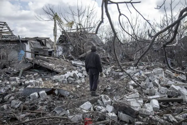 A civilian watches the destruction following a missile attack in a Donetsk town.