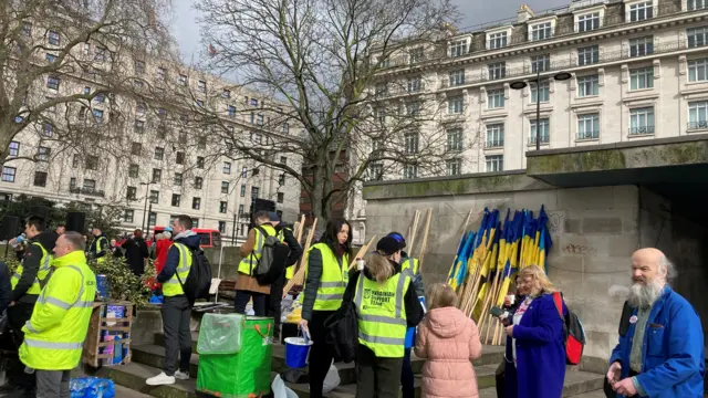 People wearing hi-vis vests gather outside the station