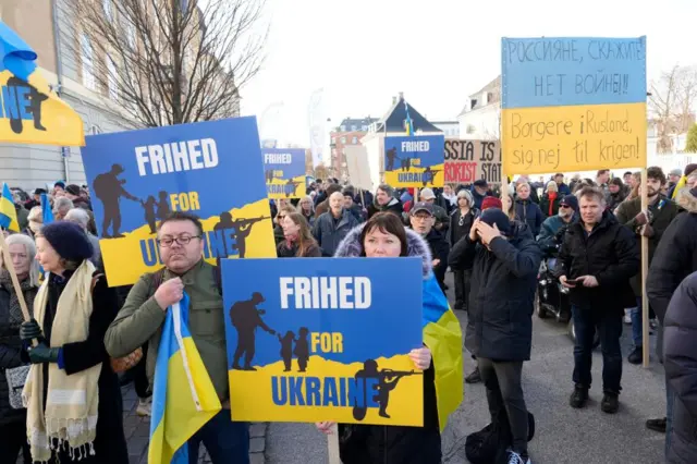 People carry placards as they attend a demonstration in front of the Russian Embassy in Copenhagen, Denmark