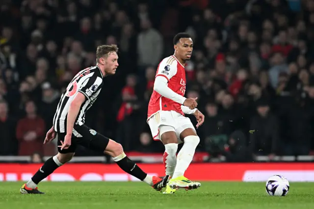 Gabriel of Arsenal passes the ball whilst under pressure from Sean Longstaff