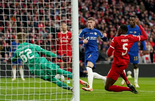 Liverpool goalkeeper Caoimhin Kelleher (left) saves a shot from Chelsea's Cole Palmer (second left) during the Carabao Cup final at Wembley Stadium, London