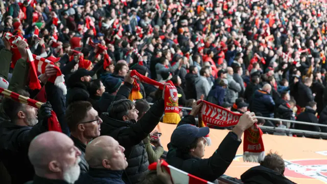 Liverpool fans hold up their scarves in the stands at Wembley