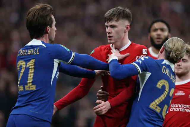 Chelsea's English midfielder Conor Gallagher (R) acts as peace-maker as Chelsea's English defender Ben Chilwell (L) and Liverpool's Northern Irish defender Conor Bradley (C) clash during the English League Cup final