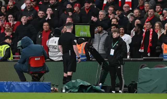 Referee Chris Kavanagh checks the VAR monitor before disallowing the goal scored by Virgil van Dijk of Liverpool