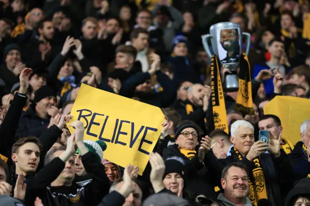 Maidstone fans hold up a banner that says 'believe' at Coventry