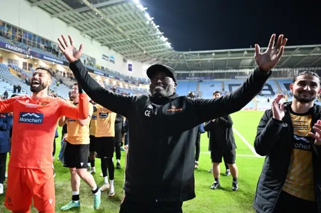 Maidstone manager George Elokobi and his players celebrate with their supporters after the end of their FA Cup run