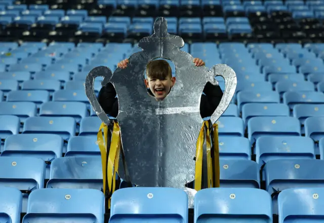 A Maidstone fan poses with a foil FA Cup