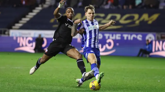 Victor Adeboyejo (left), of Bolton Wanderers, and Jason Kerr, of Wigan Athletic