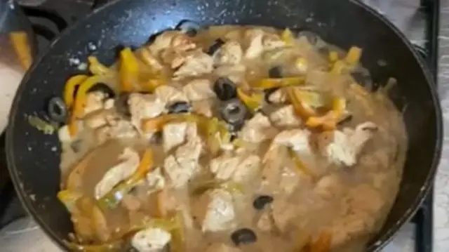 Pan on hob with a meal of chicken, pepper and olives