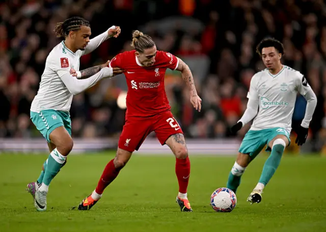 Kostas Tsimikas of Liverpool competing with Sekou Mara