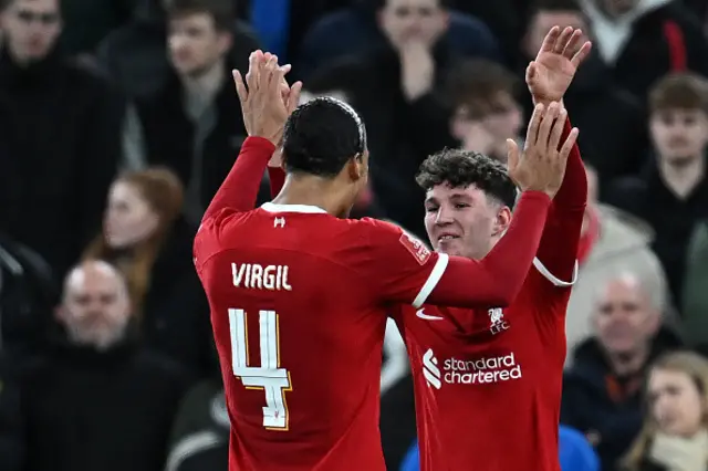 Lewis Koumas (R) celebrates with Liverpool's Dutch defender #04 Virgil van Dijk