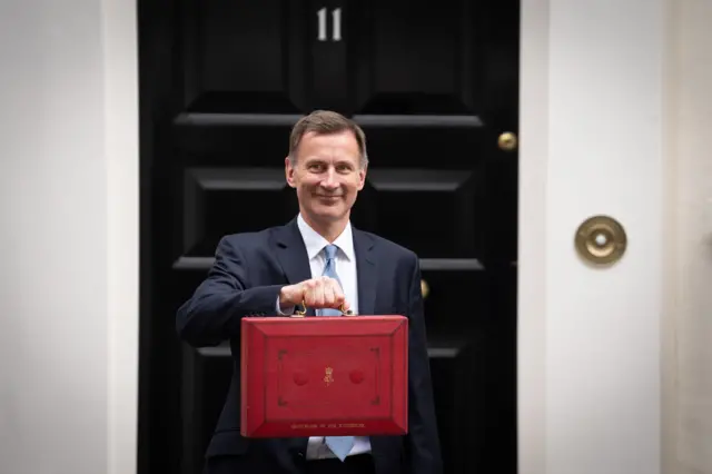 Chancellor Jeremy Hunt holds the iconic red dispatch box outside 11 Downing Street