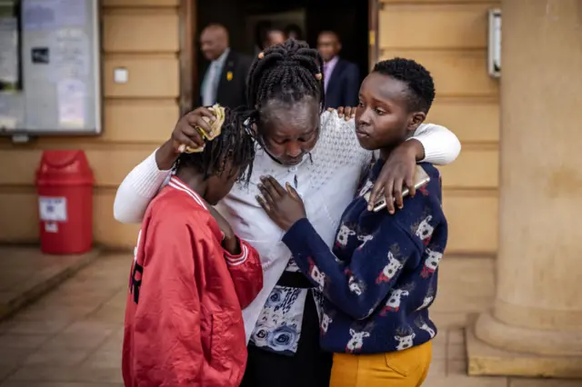 12-year-old Agnes Wanjiru's daughter Stacy Wanjiru (L), Agnes Wanjiru's sister Rose Wanyua (C) and Agnes Wanjiru's niece Esther Njoki (R) hug as they get emotional after the postponement of the hearing of the case for the alleged murder of Agnes Wanjiru by a British soldier at the Milimani Law Courts in Nairobi on November 29, 2023.