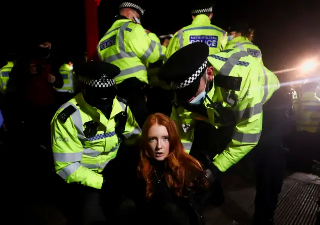 A woman is handcuffed by two police.