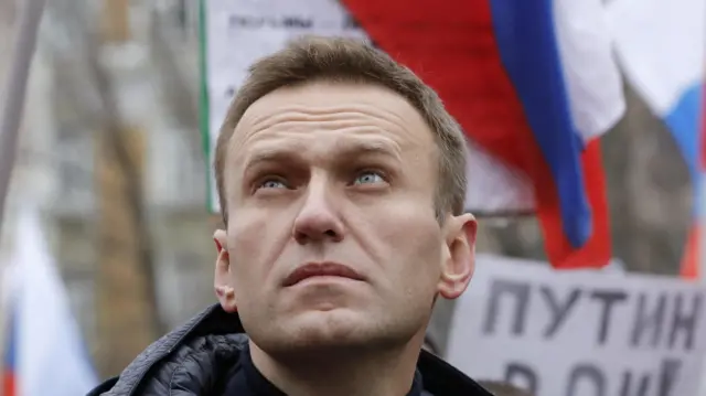 Russian opposition leader Alexei Navalny looks up as he attends a rally